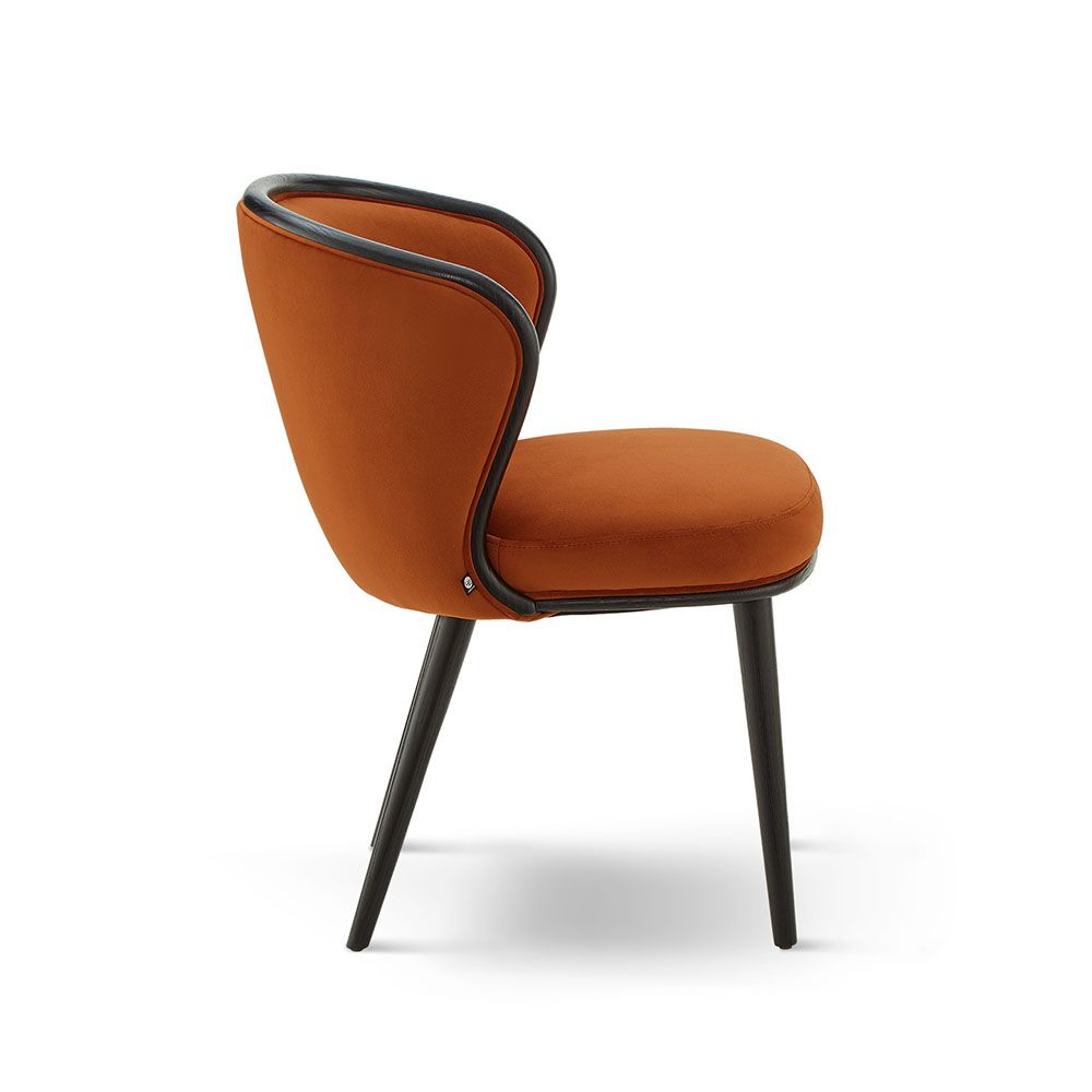 A statement recycled velvet upholstered dining chair with a curved backrest