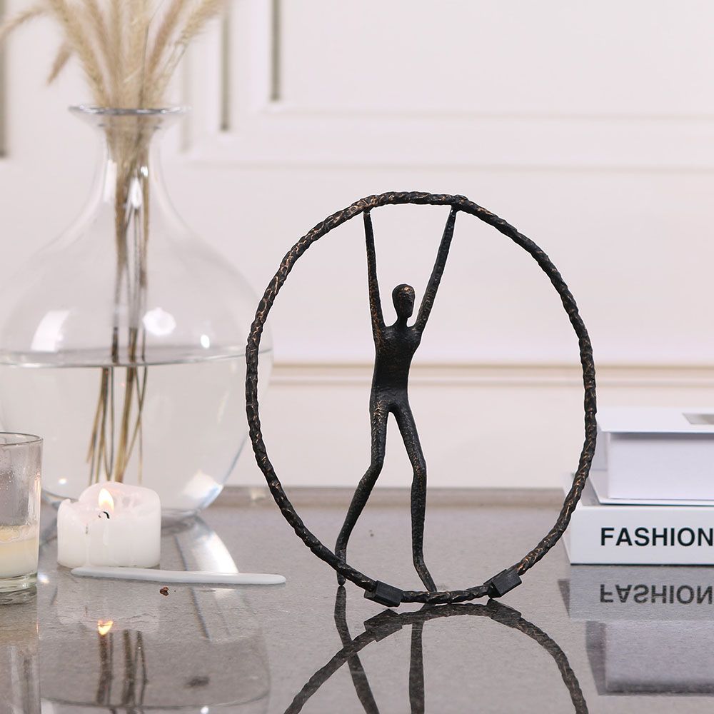 Black zinc alloy sculpture featuring person balancing in circle
