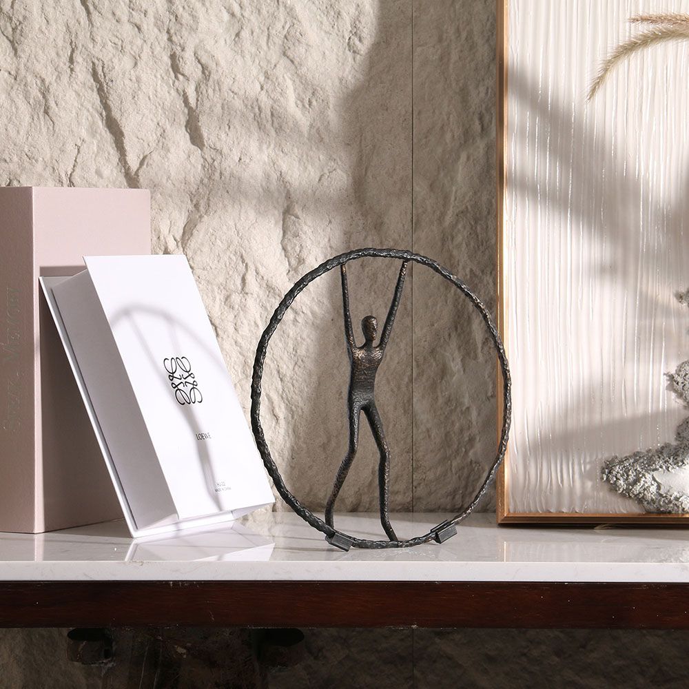 Black zinc alloy sculpture featuring person balancing in circle