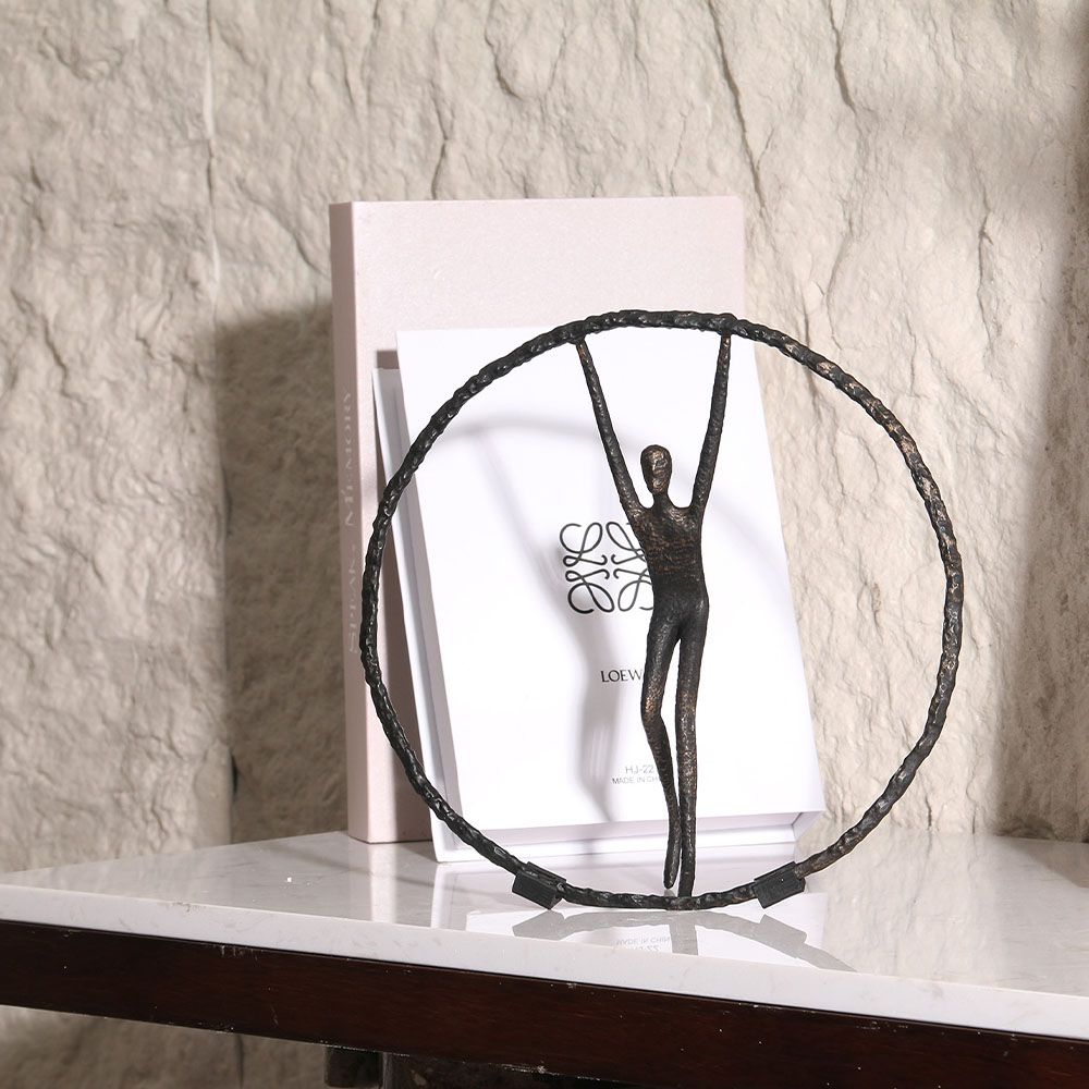 Black zinc alloy sculpture featuring person balancing in circle