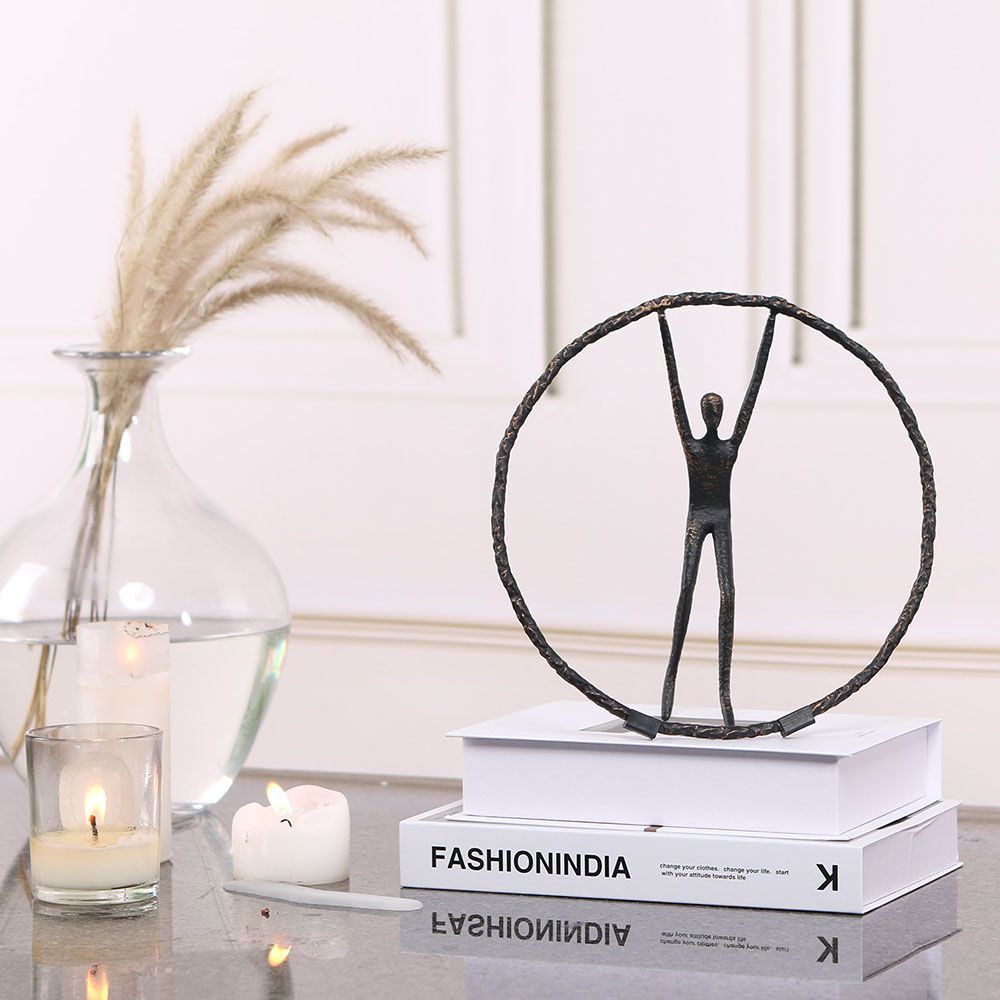Black zinc alloy sculpture featuring person balancing in circle