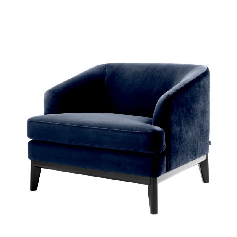 dark blue velvet armchair with exaggerated silhouette