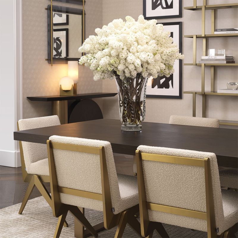 A luxurious boucle and brushed brass dining chair