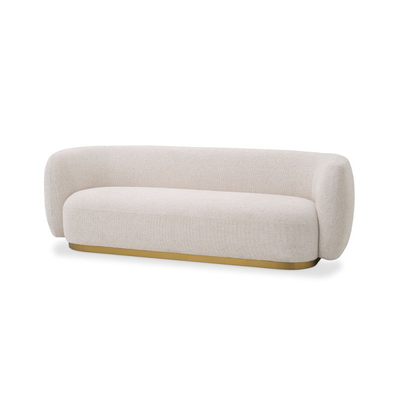 A sumptuous sofa by Eichholtz with an Lyssa Off-White upholstery and brushed brass base 