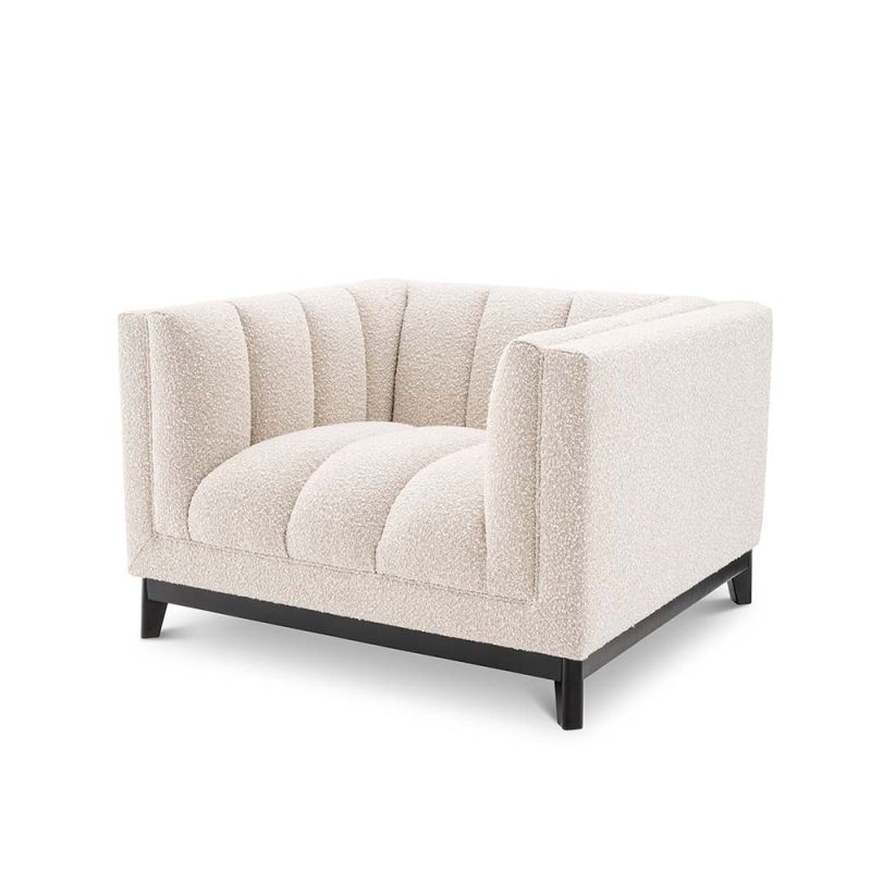 A luxurious boucle armchair in a creamy white upholstery with black legs