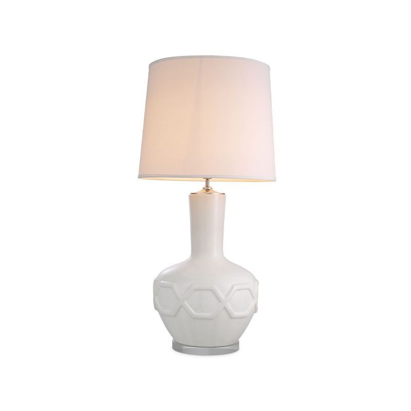 A stylish table lamp by Eichholtz with a white porcelain base featuring relief patterns, a crystal glass plinth and off-white fabric shade