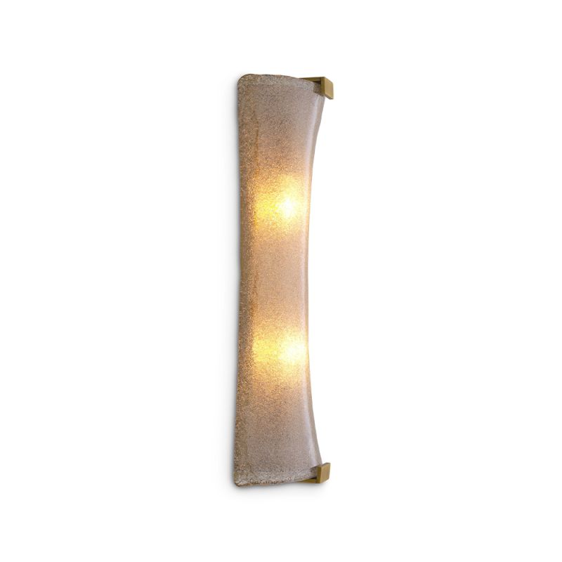 A unique wall lamp by Eichholtz with a hand blown glass curved shade and an antique brass finish