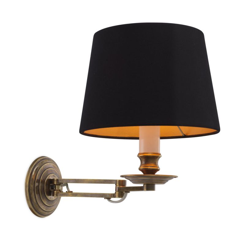 A decadent wall lamp with a black shade and vintage brass finish 