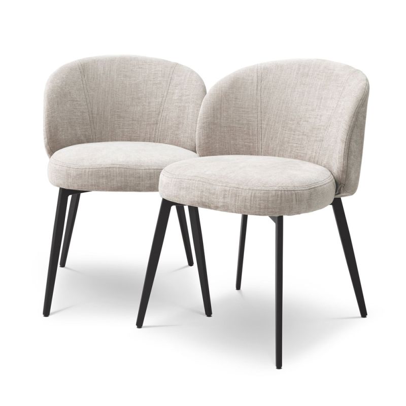 A luxury set of dining chairs from Eichholtz with a beige upholstery and tapered black legs