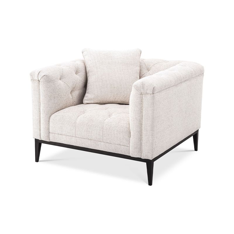 A luxurious armchair by Eichholtz with a square shaped design featuring a Lyssa off-white upholstery, deep buttoned stitching and a black gunmetal base