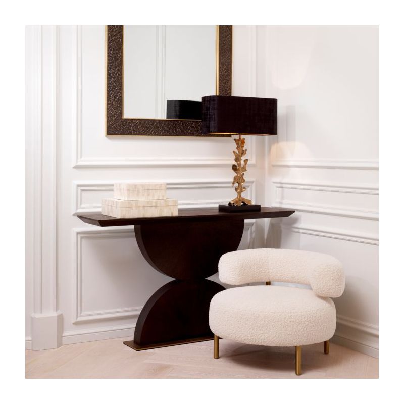 The Spring Console Table, crafted from mocha oak veneer and brushed brass, combines an elegant hourglass shape with a sleek, contemporary design.