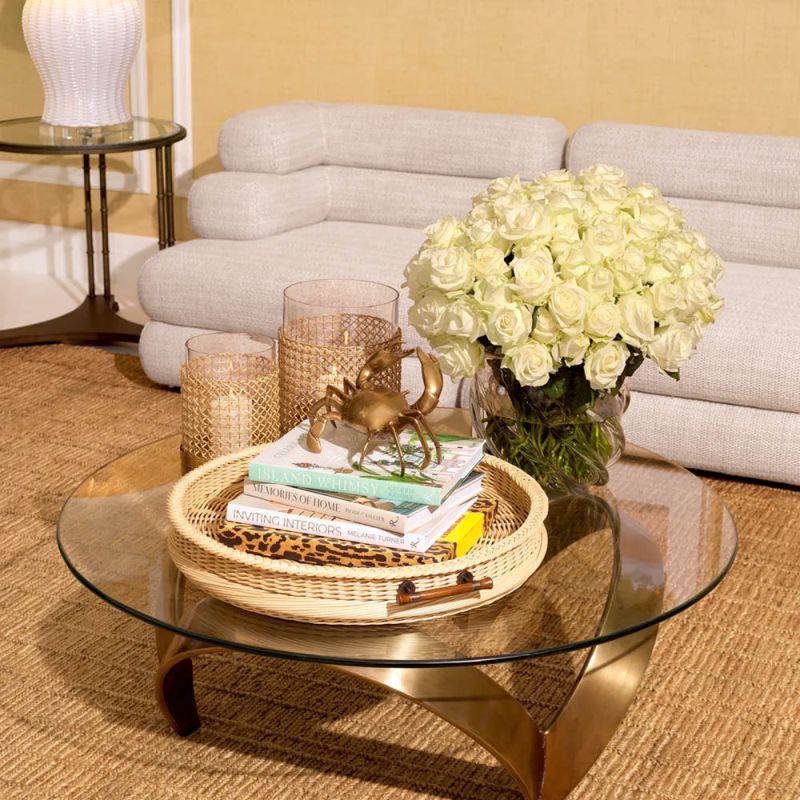 Curvaceous trio-legged coffee table in brass with round glass top