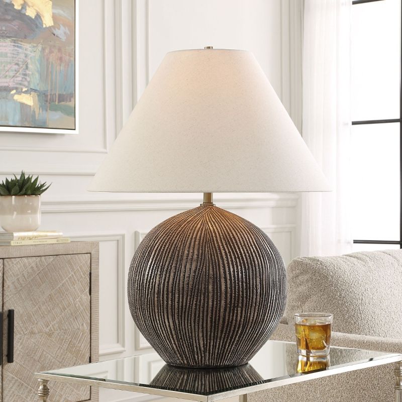 Illuminate your space with the Sayre Table Lamp, featuring a textured porcelain base in dark brown and a chic oatmeal linen shade for timeless elegance.