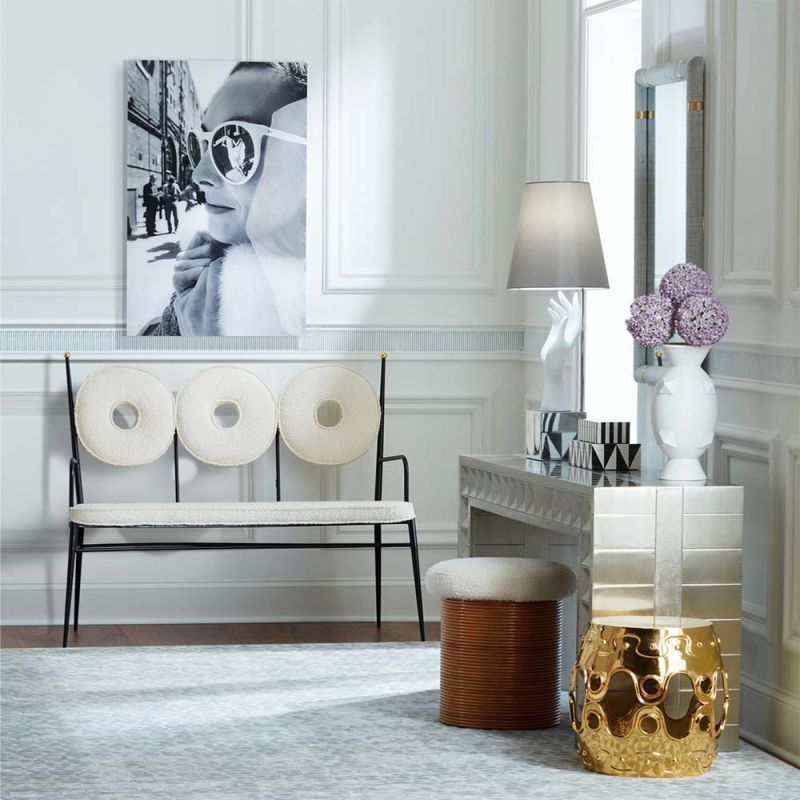 A dining bench upholstered in a boucle fabric. Placed on a blackened steel frame and polished brass sphere decorations.