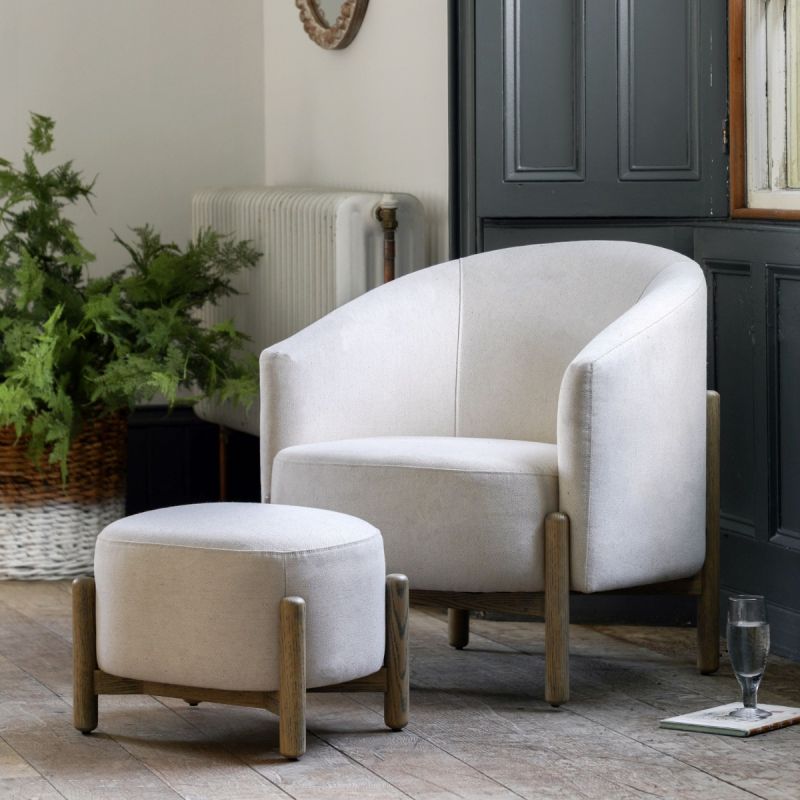 Sumptuous upholstered armchair with curved back and natural wooden legs