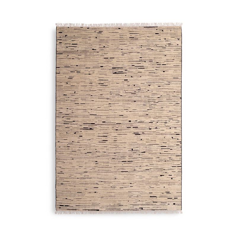 textured cream rug with black specs and a fringe