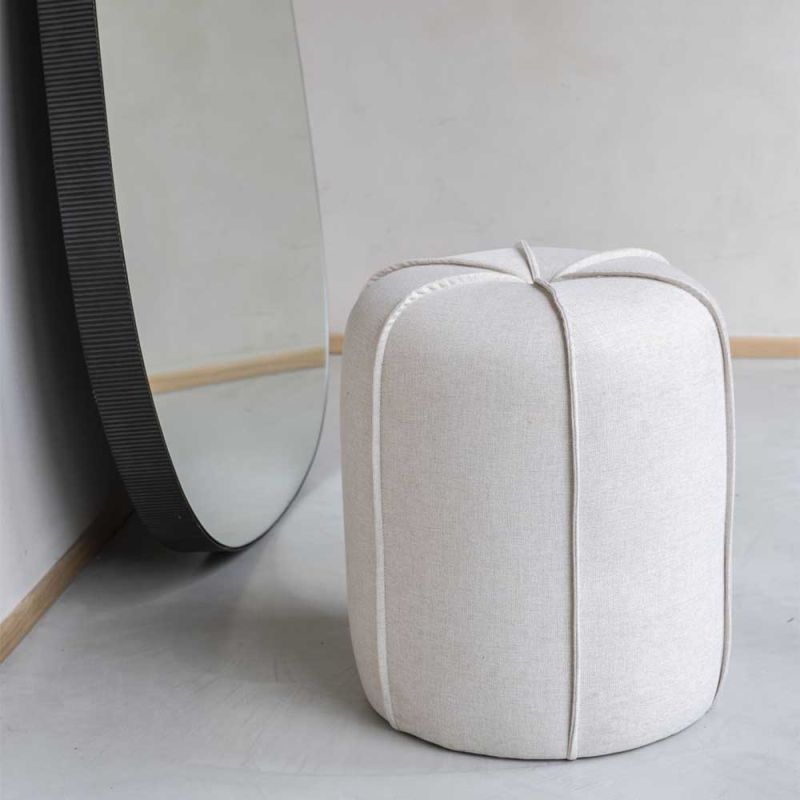 Upholstered neutral linen stool with exposed piping