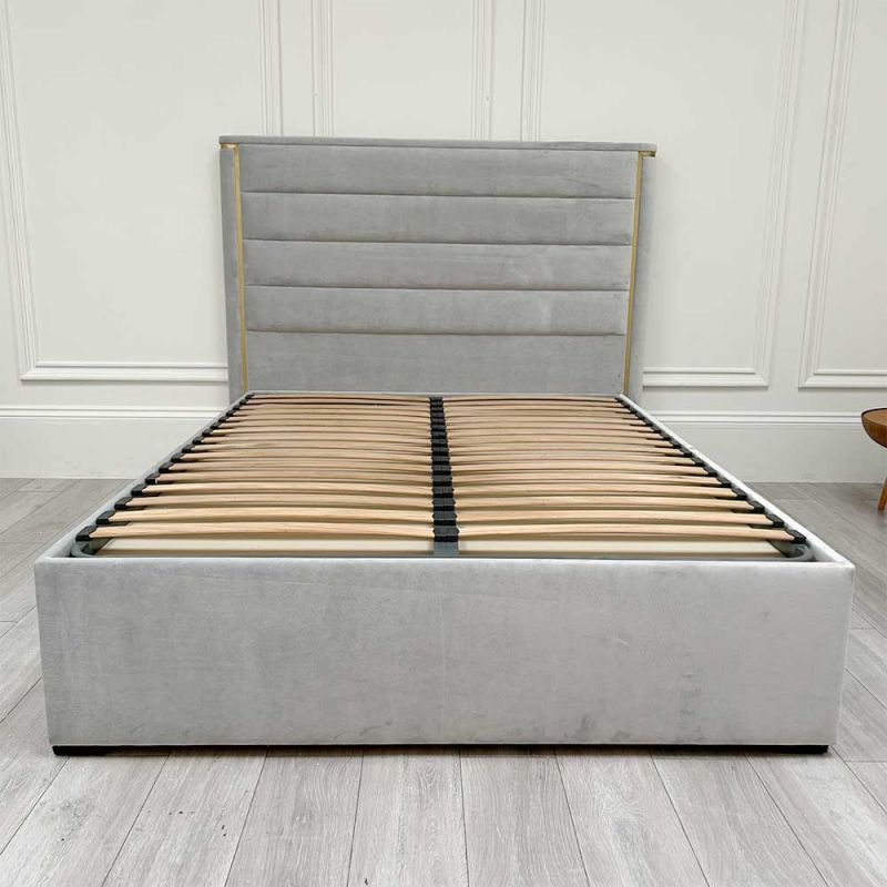 Grey velvet bed with horizontal fluting detail and brass frame as well as two drawers for storage
