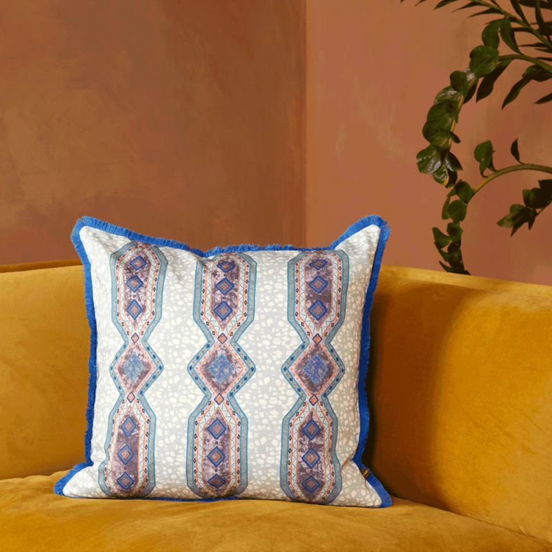 A luxury cushion by Eva Sonaike with a blue African-inspired pattern and fringing