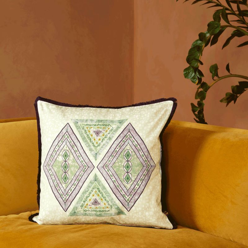 A luxury cushion by Eva Sonaike with a sage green African-inspired pattern and fringing 