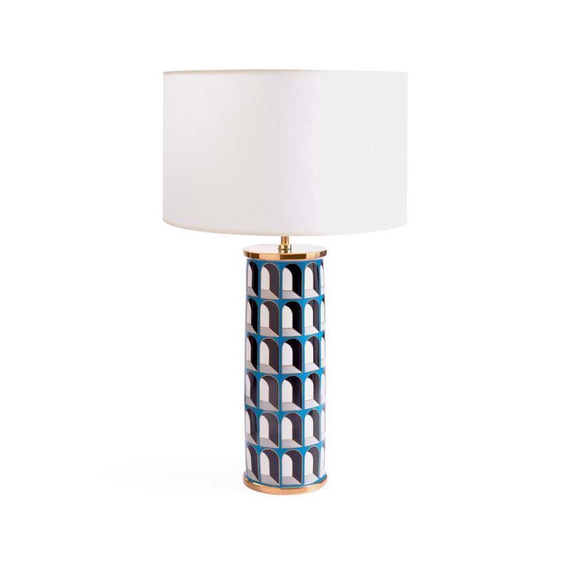 A maximalist inspired table lamp with blue archways   decorating the base, gold accents and a white paper shade