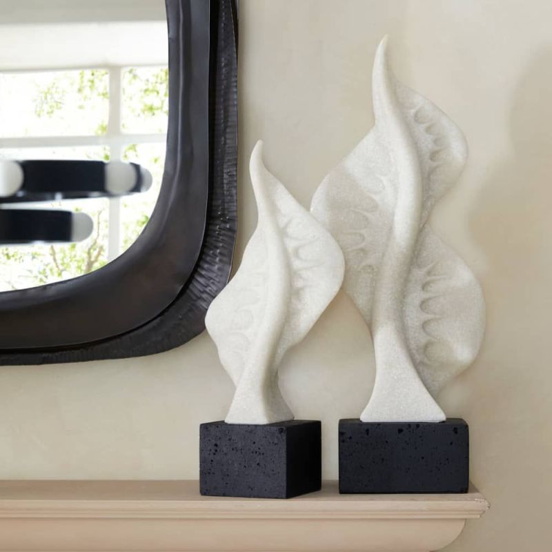 Ivory ricestone composite sculptures of marine life silhouettes, mounted on charcoal bases, bringing oceanic elegance to any space.