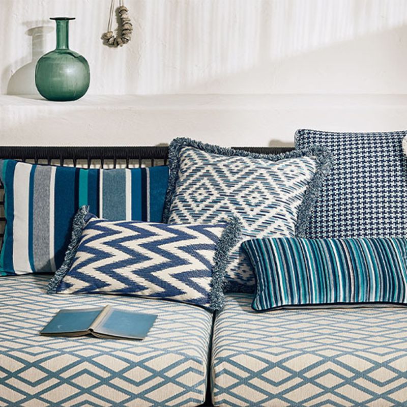 A gorgeous rectangular cushion with a blue and cream zig zag pattern, adorned with a fringe.