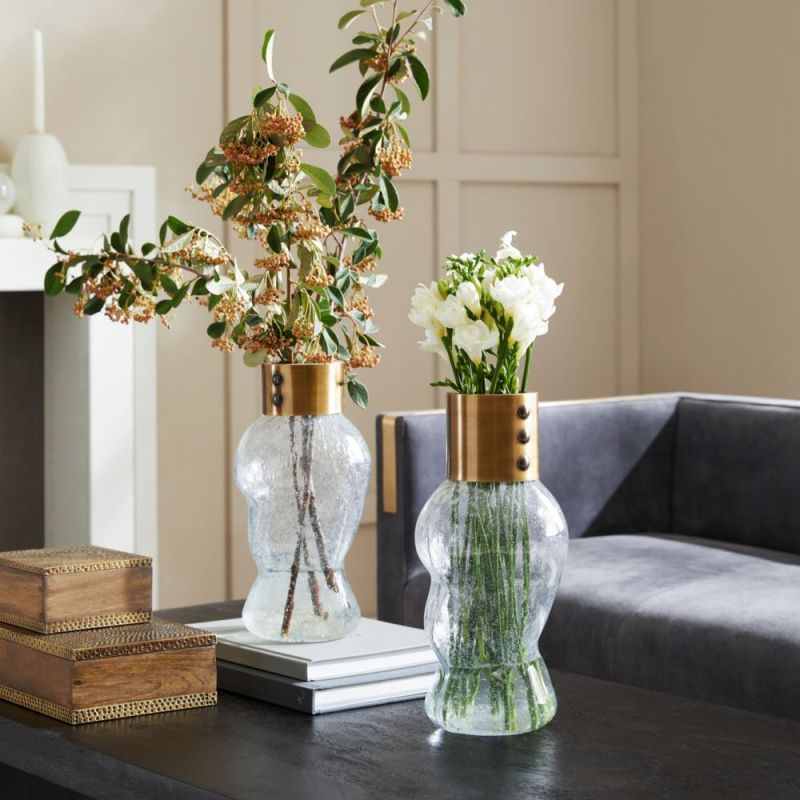 Inspired by fashion, the Decker Vases are clear, seedy glass with puff sleeve-like volume and vintage brass accents.