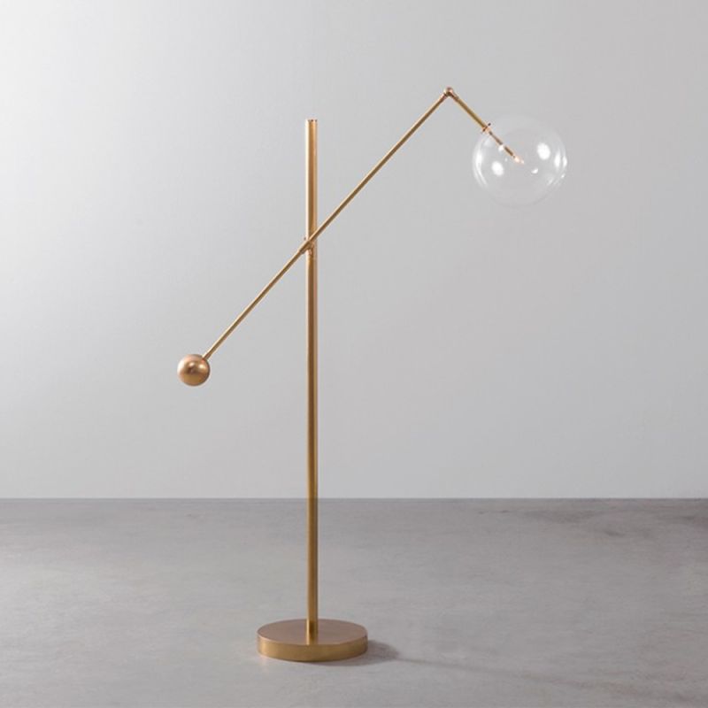 Natural brass finish floor lamp with angular frame and clear glass globe