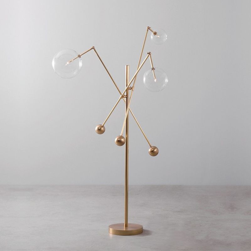 Natural brass industrial style floor lamp with 3 angular arm design with clear glass globe lampshades