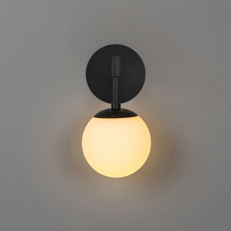 A luxury wall lamp by Schwung with a spherical glass shade mounted on a black gunmetal plate