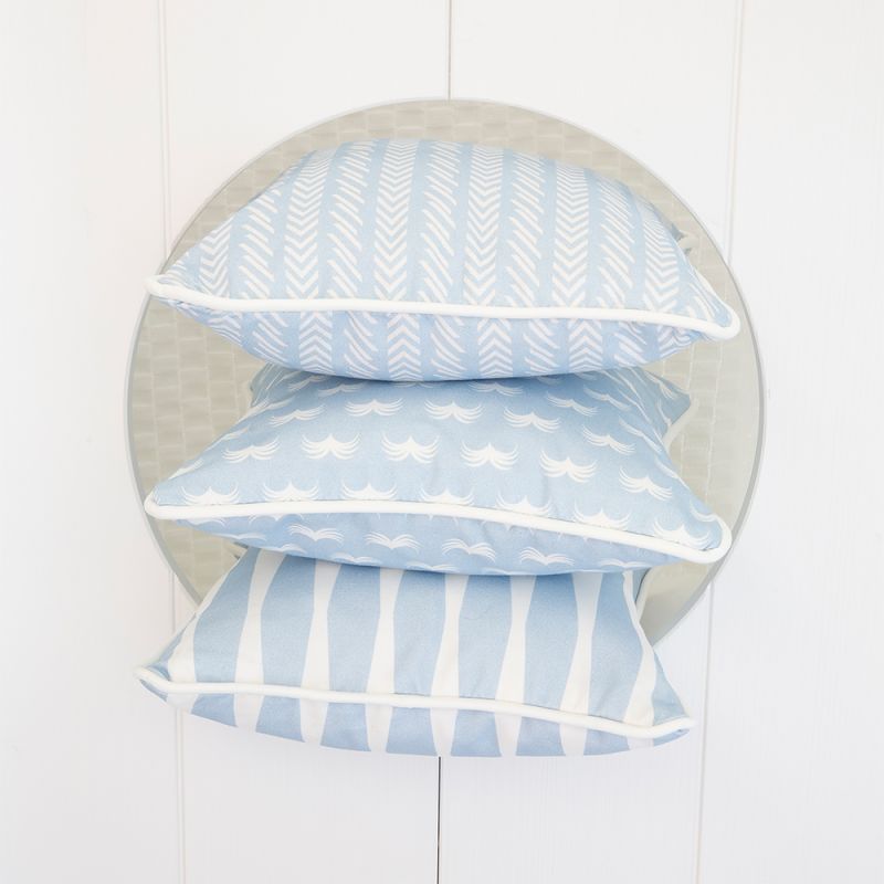 A calming light blue children's cushion with a white pattern and piping