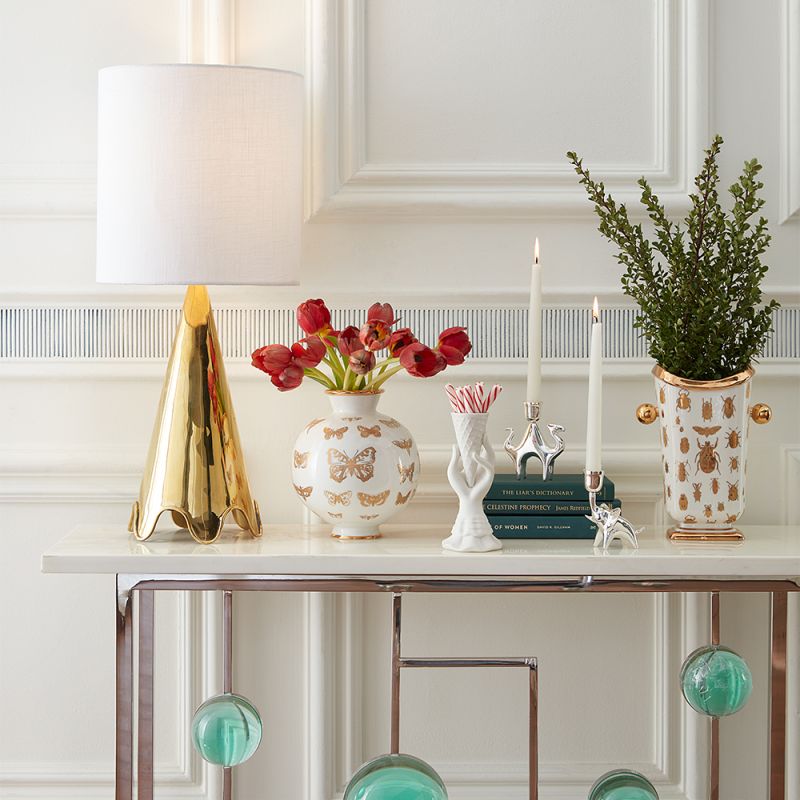 A luxurious, solid polished brass table lamp with a rippled base and a white shade