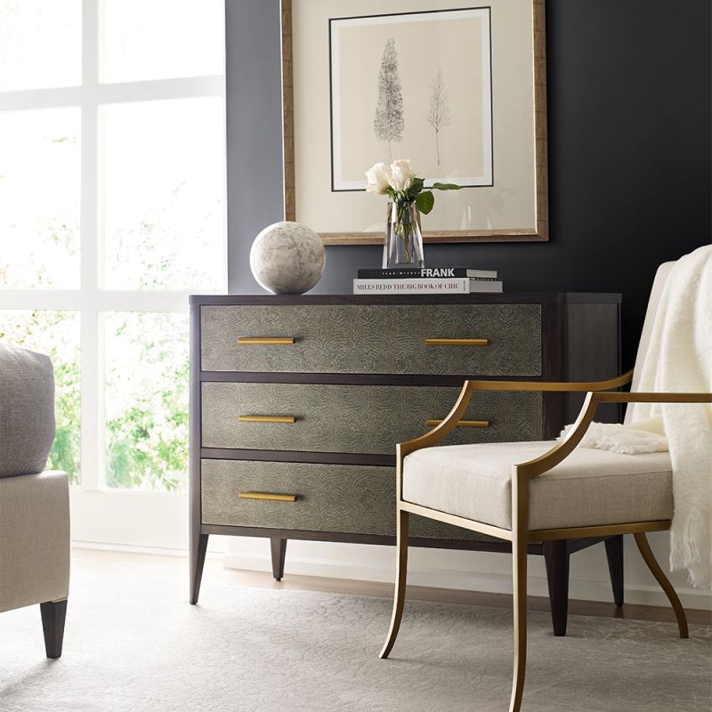 A luxurious chest with three textured drawers covered in embossed leather and finished with brushed brass handles