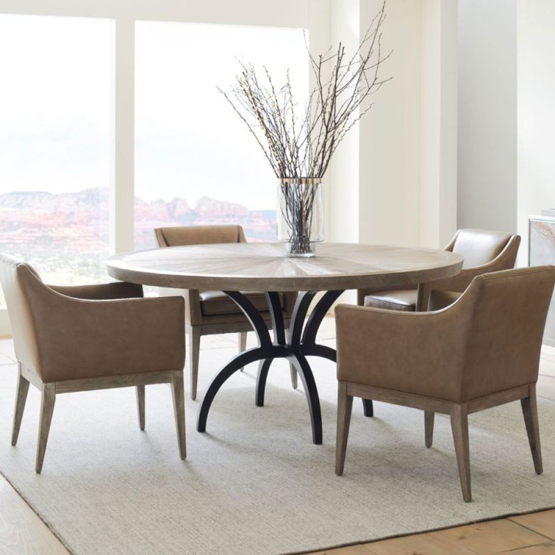 Striking round dining table with rustic bronze base and sunburst woodgrain surface