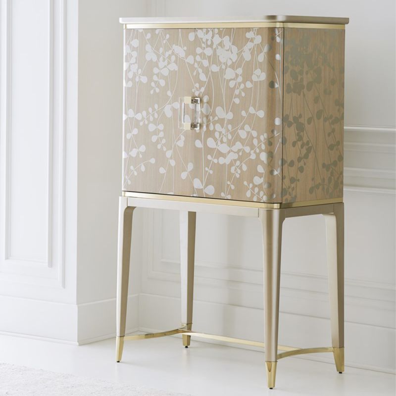 A luxury bar cabinet with leaf motif embellishments and a champagne finish