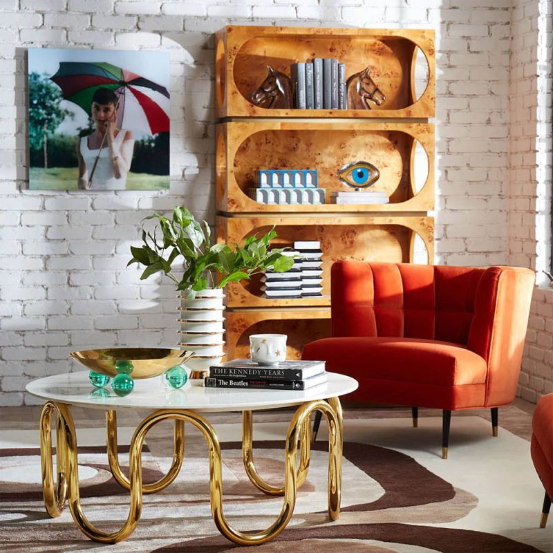 A luxury armchair by Jonathan Adler with a gorgeous red upholstery and beautiful brass capped feet
