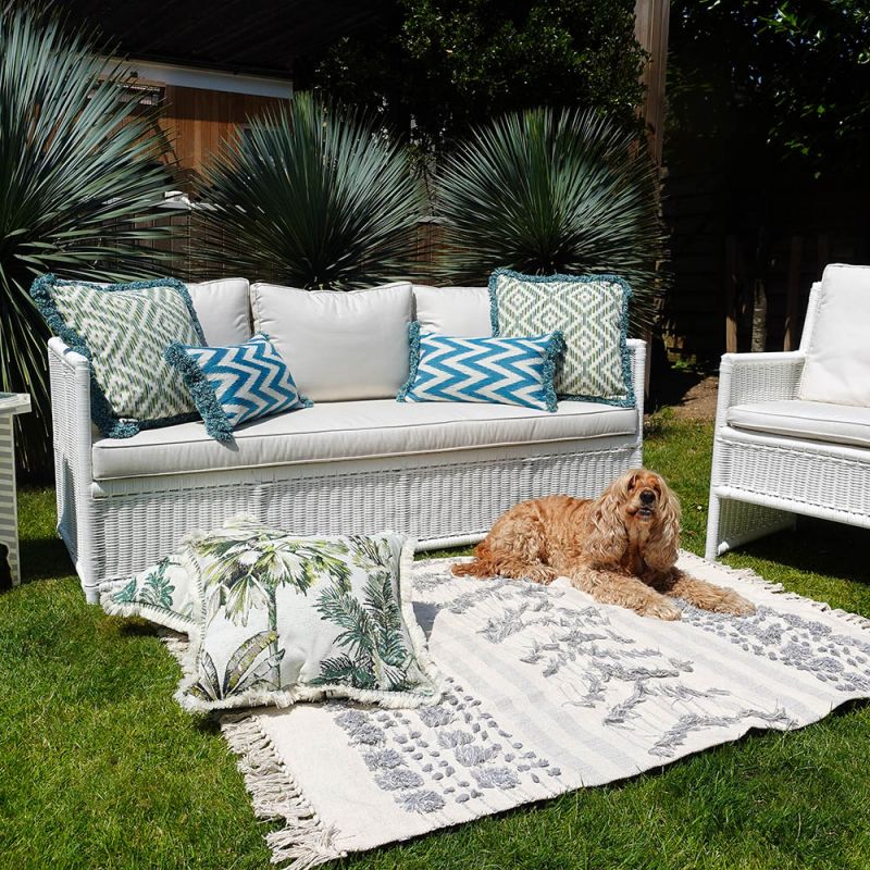 A tropic outdoor cushion with fringe details.