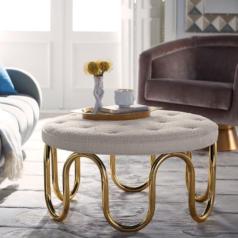 Luxurious circular ottoman upholstered in ivory boucle fabric with polished brass pipe base