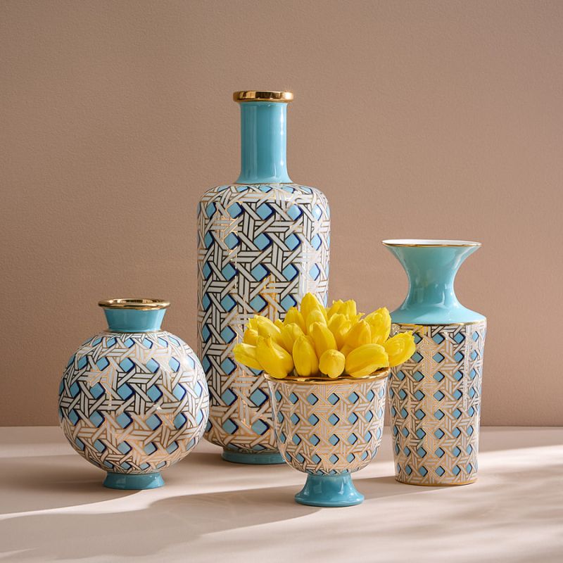A porcelain pedestal bowl with a light blue glaze and gold caning, combining preppy sophistication with modern elegance.