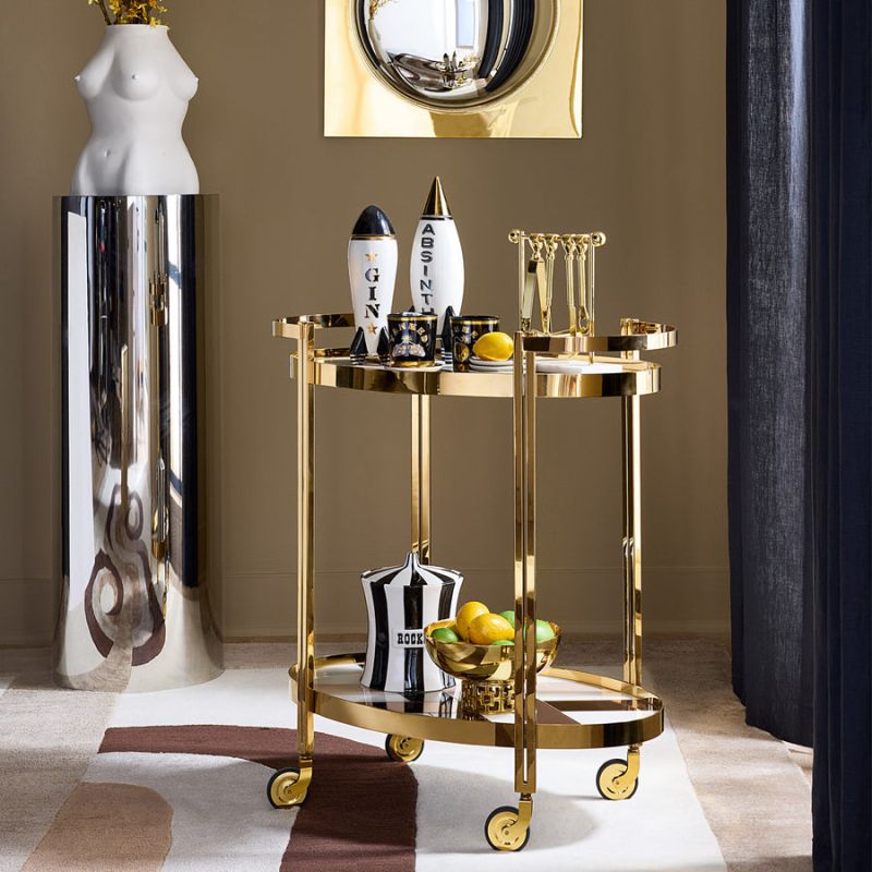 The Chambeige Bar Cart features back-painted glass shelves in a captivating Chambeige hue, framed by polished brass for a glamorous touch.