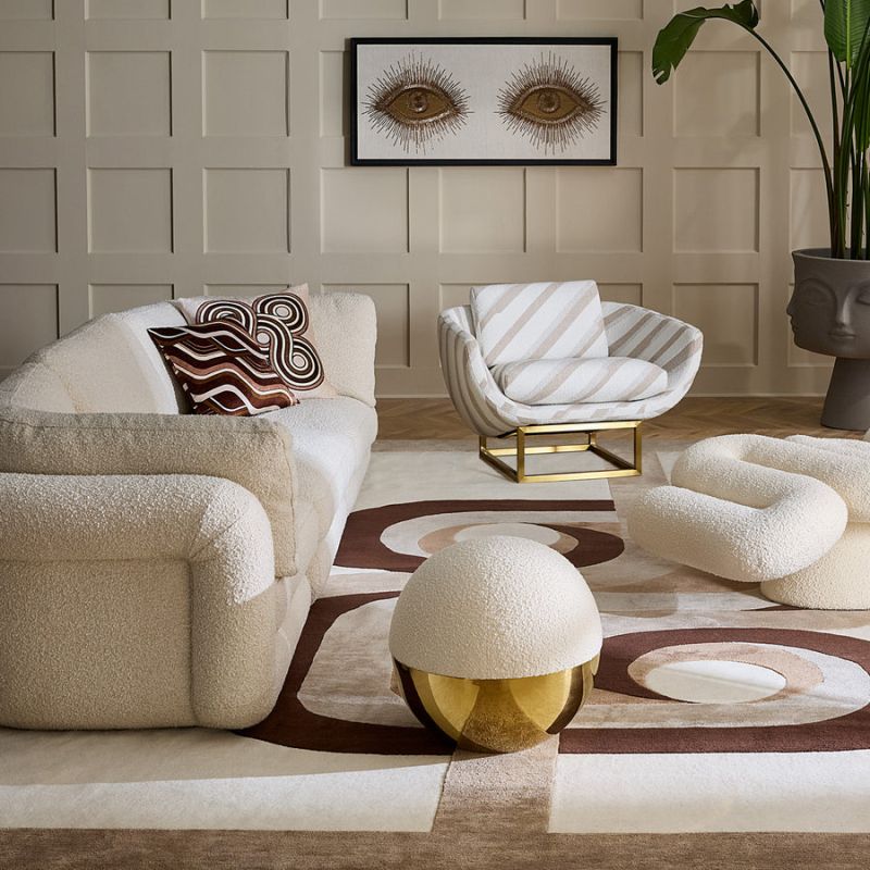 The Beaumont Lounge Chair combines minimalist design with luxurious comfort, featuring a sculptural brass base and elegant upholstery in velvet or bouclé.