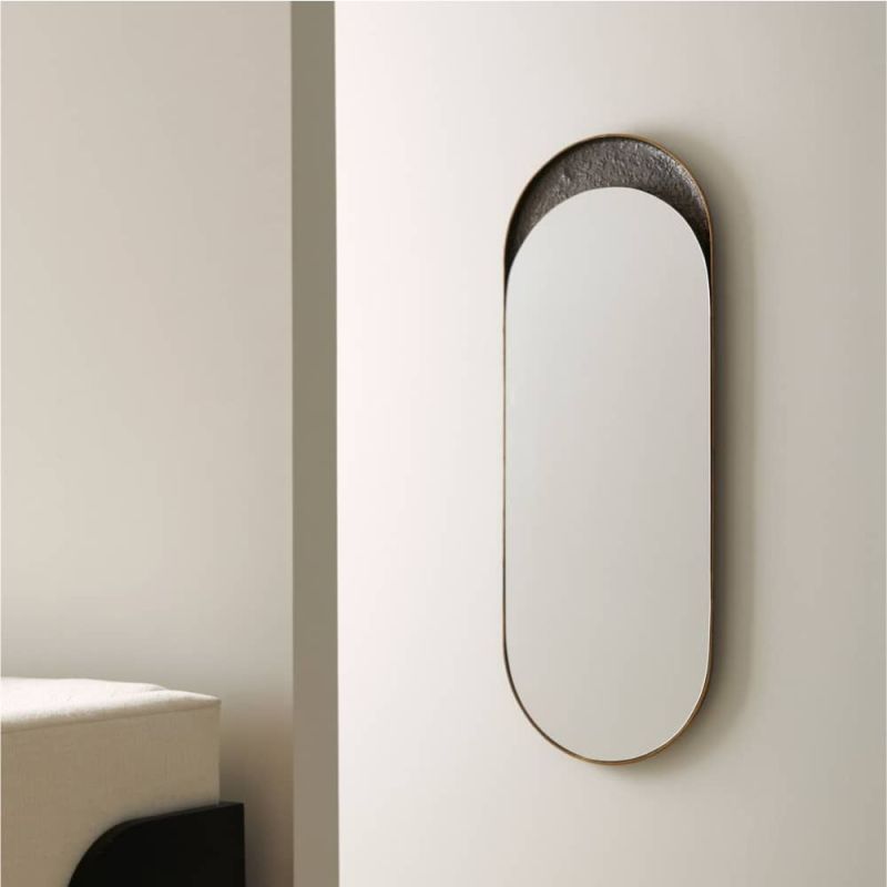 The Inset Long Mirror features a glossy surface within a textured bronze-plated aluminium frame, offering versatile display options and unique variations in finish.