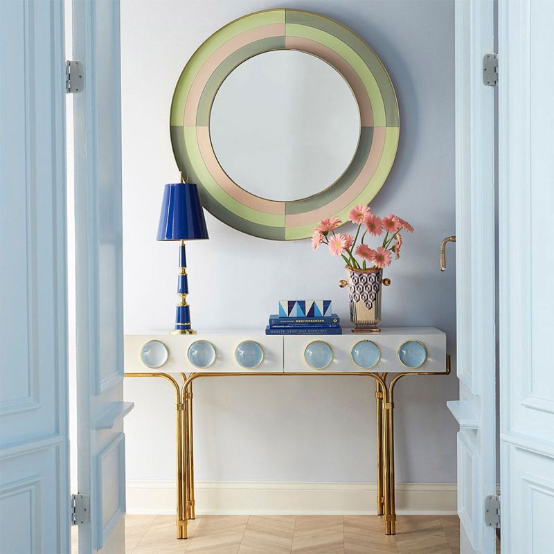 A futuristic white console table with blue acrylic cabochons and a polished brass base 