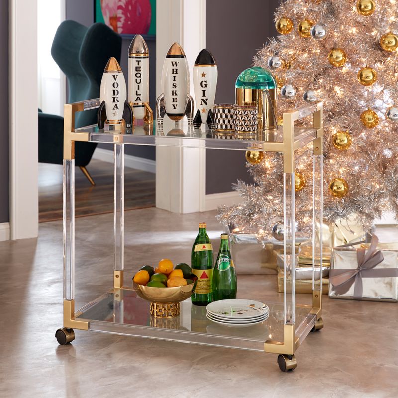 An understated glamorous bar cart made from clear acrylic, brushed brass and glass 