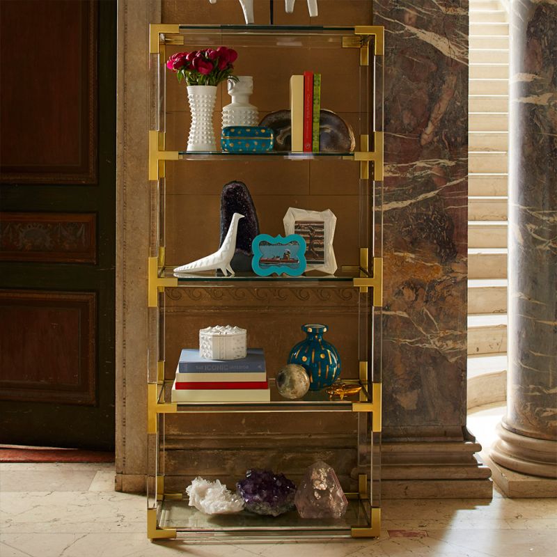 A brushed brass and acrylic shelving unit