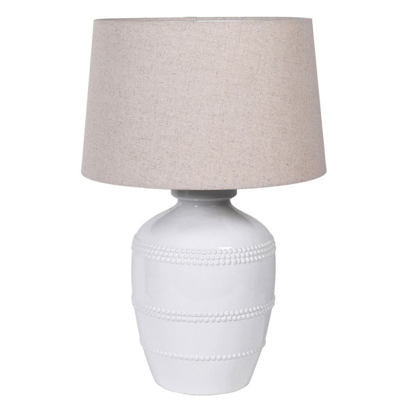 White ceramic table lamp with beading details around the base and beige linen shade