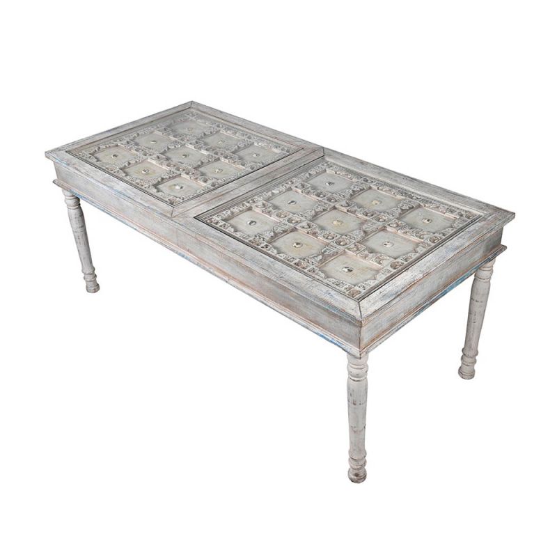 Intricately carved dining table in a light washed-wood