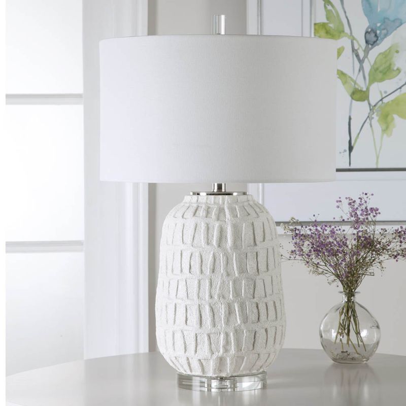 A modern side lamp with a textured white ceramic base and luxury linen shade