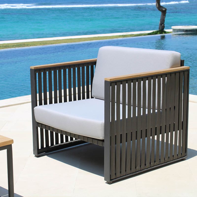 A sophisticated armchair from Willow's Outdoor collection with a bespoke sunbrella cushion upholstery and grey strapping